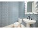 Chic powder room with patterned wallpaper, pedestal sink, and decorative mirror at 7935 Flagship Ln, Johns Island, SC 29455