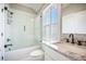 Bathroom featuring a shower-over-tub combination, white subway tile, granite vanity top, and matte black fixtures at 7935 Flagship Ln, Johns Island, SC 29455