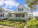 Inviting white cottage-style home with a covered porch, green landscaping, and a pathway at 7935 Flagship Ln, Johns Island, SC 29455