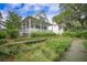 Beautiful white home with a spacious porch and lush landscaping at 7935 Flagship Ln, Johns Island, SC 29455