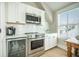 Modern kitchenette with stainless steel appliances, white cabinets, and quartz countertops at 7935 Flagship Ln, Johns Island, SC 29455