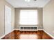 Neutral bedroom features hardwood floor, window with white shade, and base shelving at 7947 Vermont Rd, North Charleston, SC 29418