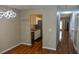 Well-lit dining room with modern lighting fixture, hardwood floors, and an open view to the kitchen and hallway at 7947 Vermont Rd, North Charleston, SC 29418