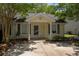 Charming single-story home featuring a cozy front porch, manicured landscaping, and a well-maintained yard at 7947 Vermont Rd, North Charleston, SC 29418