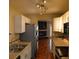 Efficient kitchen featuring stainless steel appliances, updated cabinets, and views into the living room with fireplace at 7947 Vermont Rd, North Charleston, SC 29418