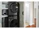 This is a laundry room with gray front loading washer and dryer units that are stacked on top of each other at 7947 Vermont Rd, North Charleston, SC 29418