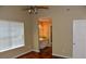 Comfortable primary bedroom featuring hardwood floors and a view to the ensuite bathroom with updated vanity at 7947 Vermont Rd, North Charleston, SC 29418