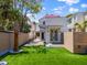 Beautiful backyard featuring artificial turf, privacy fence, and charming white home exterior at 80 Smith St, Charleston, SC 29401
