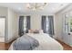 Bright bedroom featuring wood floors, a gold chandelier and blue drapes and linens at 80 Smith St, Charleston, SC 29401