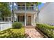 Stunning home featuring a covered porch, white picket fence and a brick walkway to the front door at 80 Smith St, Charleston, SC 29401