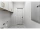 Well-organized laundry room with stylish tile flooring, gray walls, and white shaker cabinets at 80 Smith St, Charleston, SC 29401