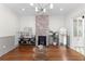 Sunlit living room featuring a brick fireplace, glass coffee table, and hardwood floors at 80 Smith St, Charleston, SC 29401