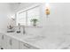 Bright laundry room sink area with white marble countertop, subway tile backsplash, and designer gold fixtures at 80 Smith St, Charleston, SC 29401