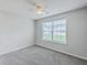Bedroom features neutral paint, carpet, ceiling fan and window with backyard view at 8028 Vermont Rd, North Charleston, SC 29418