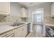 Well-lit kitchen featuring stainless steel appliances, stylish backsplash, and hardwood floors at 8028 Vermont Rd, North Charleston, SC 29418