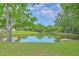 Scenic view of a tranquil pond surrounded by lush greenery and Spanish moss at 8028 Vermont Rd, North Charleston, SC 29418