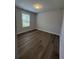 Bright bedroom featuring modern wood flooring, a window, and neutral wall paint at 819 Burger St, Charleston, SC 29407