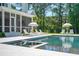 Beautiful backyard swimming pool with spa, patio, white furniture, and lush green trees at 821 Bulls Bay Blvd, Mount Pleasant, SC 29429
