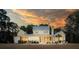 Beautiful white home at dusk, featuring a screened porch, pool, and landscaped backyard lawn at 821 Bulls Bay Blvd, Mount Pleasant, SC 29429