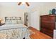 Cozy bedroom with floral bedding, wood floors, ceiling fan, and chest of drawers at 8346 Chisolm Plantation Rd, Edisto Island, SC 29438