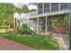 The rear exterior featuring stairs, a patio underneath, and beautifully landscaped backyard at 8346 Chisolm Plantation Rd, Edisto Island, SC 29438