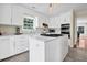 Well-lit kitchen with white cabinets, stainless steel appliances, stone countertops, and a breakfast bar island at 8346 Chisolm Plantation Rd, Edisto Island, SC 29438