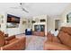 Cozy living room with hardwood floors, brick fireplace, comfortable seating, and a ceiling fan at 8346 Chisolm Plantation Rd, Edisto Island, SC 29438