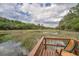 Relaxing marsh view with wooden chair, showing the beautiful wetland ecosystem at 8346 Chisolm Plantation Rd, Edisto Island, SC 29438