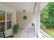 Welcoming porch features white railings, neutral walls and trim, and views of the surrounding greenery at 8346 Chisolm Plantation Rd, Edisto Island, SC 29438