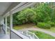 Open porch with white railings offers peaceful view of the gravel driveway and the lush greenery beyond at 8346 Chisolm Plantation Rd, Edisto Island, SC 29438