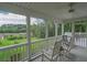Relaxing screened porch with rocking chairs overlooking the picturesque backyard and trees at 8346 Chisolm Plantation Rd, Edisto Island, SC 29438