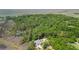 Stunning aerial view of the secluded home nestled within lush, dense trees and bordered by marshland at 8970 Palmetto Rd, Edisto Island, SC 29438