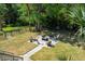 Private backyard featuring mature landscaping, wrought iron fence and patio area with plenty of seating and firepit at 8970 Palmetto Rd, Edisto Island, SC 29438