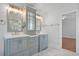 Bright bathroom featuring double vanity with gray cabinets and white marble tile flooring at 8970 Palmetto Rd, Edisto Island, SC 29438