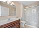 Bathroom with a wooden vanity, toilet, wallpaper, and glass-enclosed shower at 8970 Palmetto Rd, Edisto Island, SC 29438
