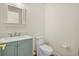 Cozy bathroom with white toilet and teal vanity with modern faucet and mirror at 8970 Palmetto Rd, Edisto Island, SC 29438