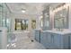 The updated bathroom boasts double sinks, marble floors, soaking tub, walk in shower, and scenic outdoor views at 8970 Palmetto Rd, Edisto Island, SC 29438