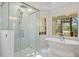 Updated bathroom with marble floors, soaking tub, glass shower, and scenic outdoor views at 8970 Palmetto Rd, Edisto Island, SC 29438