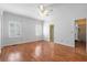 Spacious bedroom with hardwood floors, two windows with shutter and a ceiling fan at 8970 Palmetto Rd, Edisto Island, SC 29438