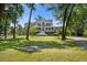 Charming two-story home with lush landscaping, Southern-style porch and fire pit for outdoor enjoyment at 8970 Palmetto Rd, Edisto Island, SC 29438