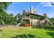 Rear exterior view of a charming two-story home with stairs, deck, and lush landscaping at 8970 Palmetto Rd, Edisto Island, SC 29438