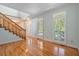 Bright foyer featuring hardwood floors, staircase, and natural light from large windows at 8970 Palmetto Rd, Edisto Island, SC 29438