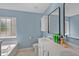 Bright bathroom with double vanity, bathtub, shower, blue paint, and large mirrors at 9923 Honeylocust Ln, Ladson, SC 29456
