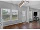 Well-lit dining space with hardwood floors, modern chandelier, and large windows providing a bright and airy feel at 9923 Honeylocust Ln, Ladson, SC 29456
