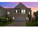 Two-story home showcasing the front facade, garage, and well-lit entrance at 9923 Honeylocust Ln, Ladson, SC 29456