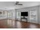 Spacious living room with hardwood floors, a ceiling fan, and large windows providing ample sunlight at 9923 Honeylocust Ln, Ladson, SC 29456