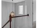 Staircase with wood handrail, white risers, neutral paint, and decorative chandelier at 9923 Honeylocust Ln, Ladson, SC 29456