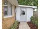 Exterior back entrance with brick siding, a white door with glass panes, and green foliage at 1010 Fiall St, Charleston, SC 29407