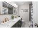 Well-lit bathroom with modern dual sinks, a large mirror, and a shower with grey tiling at 1010 Fiall St, Charleston, SC 29407