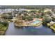 Aerial view of a community pool and playground on a small peninsula surrounded by a lake and trees at 1027 Wayfarer Ln, Charleston, SC 29412